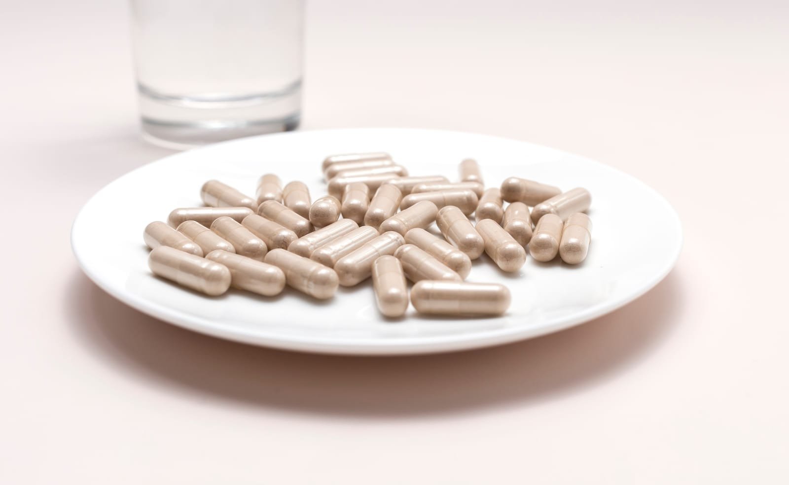 52259806_closeup-handful-of-pills-capsules-of-slippery-elm-and-glass-of-water-dietary-nutritional-supplement-medication-ulmus-fulva-herbal-remedy-concept-horizontal-plane-horizontal-plane